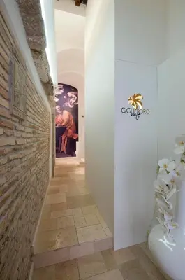 a hallway of a bathroom with a brick wall at Gigli D'Oro Suite in Rome
