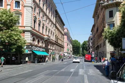 a city street with a white car driving down the street at Ottaviano Exclusive Maison in Rome