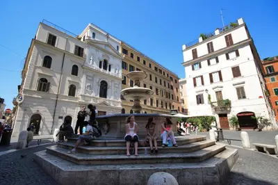 a group of people sitting on a fountain in a city at Rome Unique Monti Colosseum in Rome