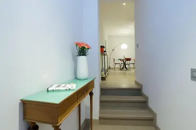 a hallway with a table and a vase with flowers on it at Rome Unique Monti Colosseum in Rome