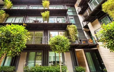 an apartment building with potted plants on the balconies at Rome Unique Monti Colosseum in Rome