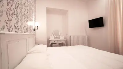 a white bedroom with a bed and a mirror at Domus Iuliae in Rome