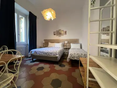 a bedroom with two beds and a living room at MiRhome Guest House in Rome