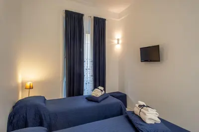 a hotel room with two beds and a window at Intra' Residenza in Trastevere in Rome