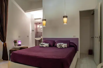 a bedroom with a purple bed with two pillows at Intra' Residenza in Trastevere in Rome