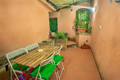 a patio with a wooden table and chairs and plants at Intra' Residenza in Trastevere in Rome