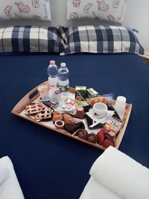 a tray of food and drinks on a bed at Pianeta roma 48 in Rome