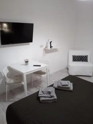 a white room with a table and a table and a chair at Pianeta roma 48 in Rome