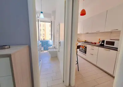 a kitchen with white cabinets and a toilet in it at Appartamento Tadolini in Rome