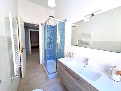 a bathroom with a sink and a glass shower at Appartamento Tadolini in Rome