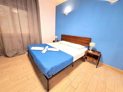 a bedroom with a bed with a blue wall at Appartamento Tadolini in Rome