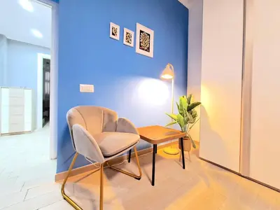 a chair and a table in a room with a blue wall at Appartamento Tadolini in Rome