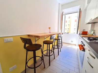 a kitchen with a wooden bar with stools at Appartamento Tadolini in Rome