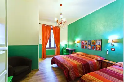 a green bedroom with two beds and a chandelier at Dream Station in Rome