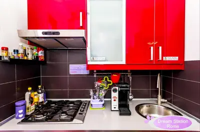 a kitchen with red cabinets and a stove top at Dream Station in Rome