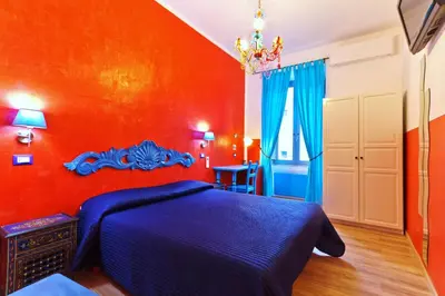 a bedroom with a blue bed and an orange wall at Dream Station in Rome