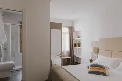 a white bedroom with a bed and a bathroom at Residenza Il Giglio in Rome