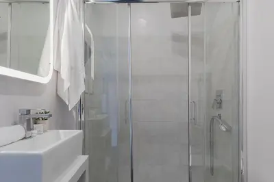 a white bathroom with a shower and a sink at Residenza Il Giglio in Rome