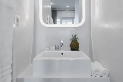 a white bathroom with a sink and a mirror at Residenza Il Giglio in Rome