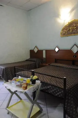a room with two beds and a table with food on it at Hotel Farini in Rome