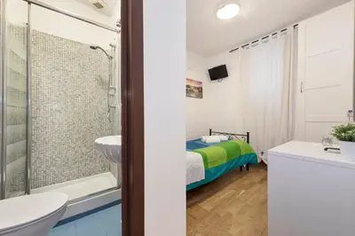 a green tiled bathroom with a sink and a shower at Locanda Sant'Anna in Rome