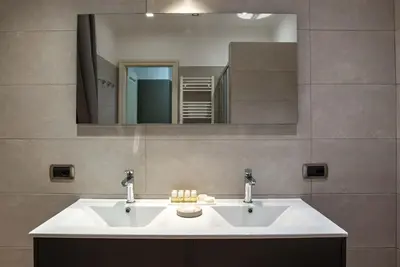 a bathroom with a white sink and a mirror at I TRE MOSCHETTIERI - D'ARTAGNAN Luxury Guest House in Rome