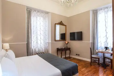 a bedroom with a bed and a table and a mirror at I TRE MOSCHETTIERI - D'ARTAGNAN Luxury Guest House in Rome