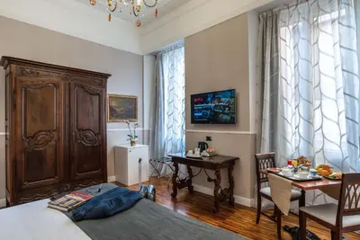 a living room with a bed and a table and chairs at I TRE MOSCHETTIERI - D'ARTAGNAN Luxury Guest House in Rome