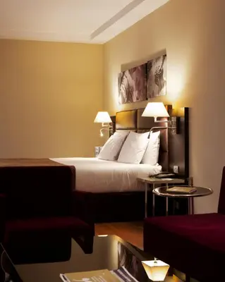 a hotel room with a bed and two tables at Eurostars Roma Aeterna in Rome