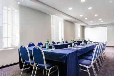 a conference room with a long table and blue chairs at Eurostars Roma Aeterna in Rome