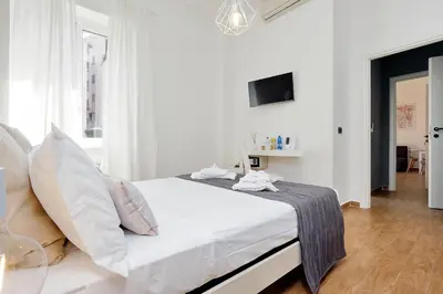 a white bedroom with a bed and a tv at Residenza Musei Vaticani in Rome