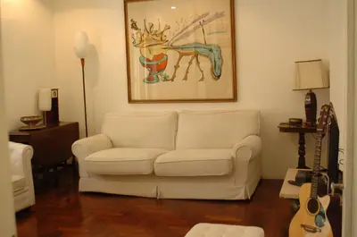 a living room with a white couch and a guitar at Roma Chic Flat Monte Mario in Rome