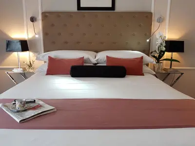 a bedroom with a large white bed with red pillows at Althea Inn Roof Terrace in Rome