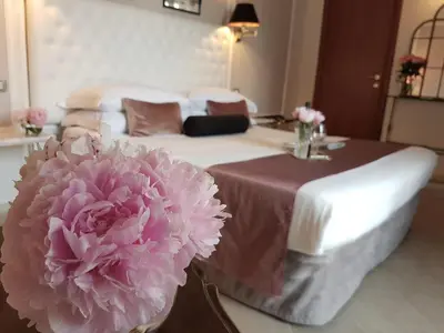 a room with a table with a pink flower on it at Althea Inn Roof Terrace in Rome