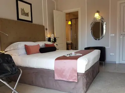 a bedroom with a large bed and a mirror at Althea Inn Roof Terrace in Rome