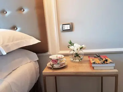 a table with a vase of flowers and books on a bed at Althea Inn Roof Terrace in Rome