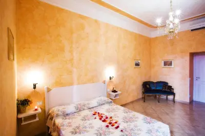 a bedroom with a bed with flowers on it at Affittacamere Guest House Glatimia in Rome
