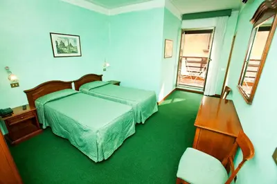 a hotel room with two beds and a window at Hotel Adriatic in Rome