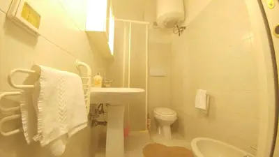 a white bathroom with a sink and a toilet at Dreaming Navona Rooms in Rome