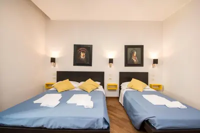 two twin beds in a room with two pictures on the wall at Seven Rooms Vatican in Rome