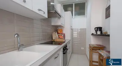 a white kitchen with a sink and a counter top at L'Olimpo di Estia in Rome