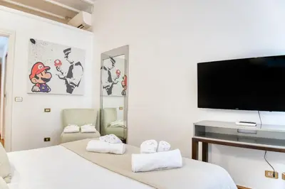 a bedroom with a flat screen tv and a bed at Orsoline Boutique Apartments - Best position in Rome in Rome
