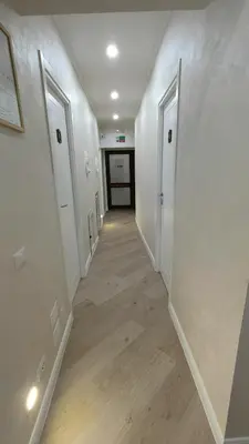 an empty hallway with white walls and wood floors at Hotel PRINCIPE AMEDEO in Rome