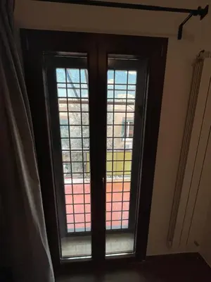 a room with two windows with stained glass at Casa Rosa in Rome