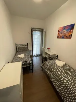 a small room with two beds and a table at Casa Rosa in Rome