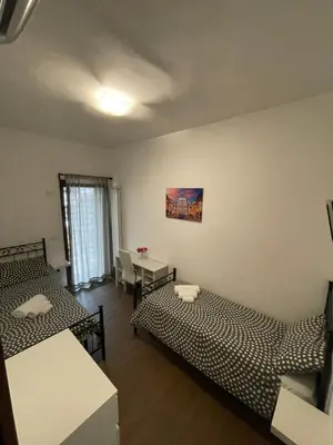a room with two beds and a desk and a table at Casa Rosa in Rome