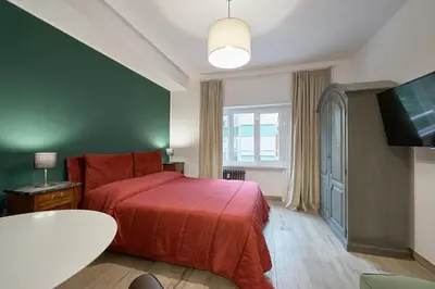 a bedroom with a red bed and a flat screen tv at Interno 9 a San Pietro in Rome