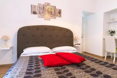 a large bed with two red pillows on it at Amor Vatican Domus in Rome