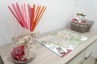 a table with a vase filled with red straws and a map at Amor Vatican Domus in Rome