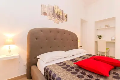 a bedroom with a large bed with a large headboard at Amor Vatican Domus in Rome